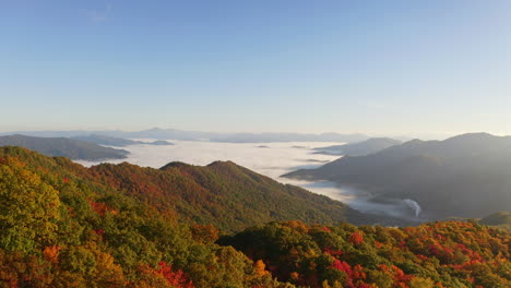 Aerial-view-drone-of-Smokey-Mountains-in-the-fall-with-colorful-leaves-overlooking-the-foggy,-misty-overcast-cloudscape---seasons,-pine,-high,-reveal,-earth,-beauty-in-nature