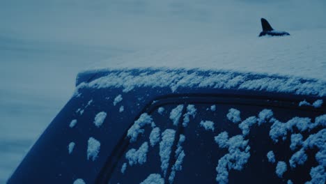 snowfall on a roof and window of a car