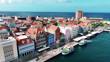 El-Dron-Vuela-Lejos-De-Las-Antiguas-Casas-Coloridas-En-El-Muelle-Comercial-En-Willemstad-Curacao-Imágenes-Aéreas-4k