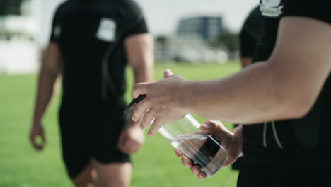 a young rugby player drinking water while taking