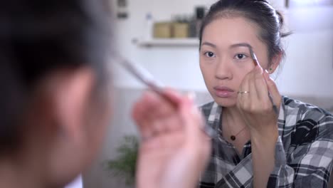 Asian-woman-doing-makeup-at-home