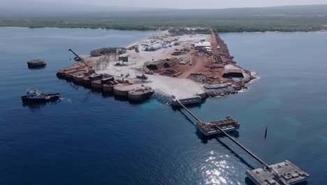 aerial backwards shot of terminal construction site named cabo rojo in caribbean sea of dominican republic - future concept for new hotels and cruiser ships