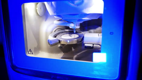 Dental machine in blue light. Advanced equipment for making ceramic teeth. Modern technologies in dentistry.