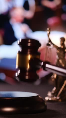 hand forcefully hitting a gavel symbolizing justice and legal decisions in a courtroom. vertical video