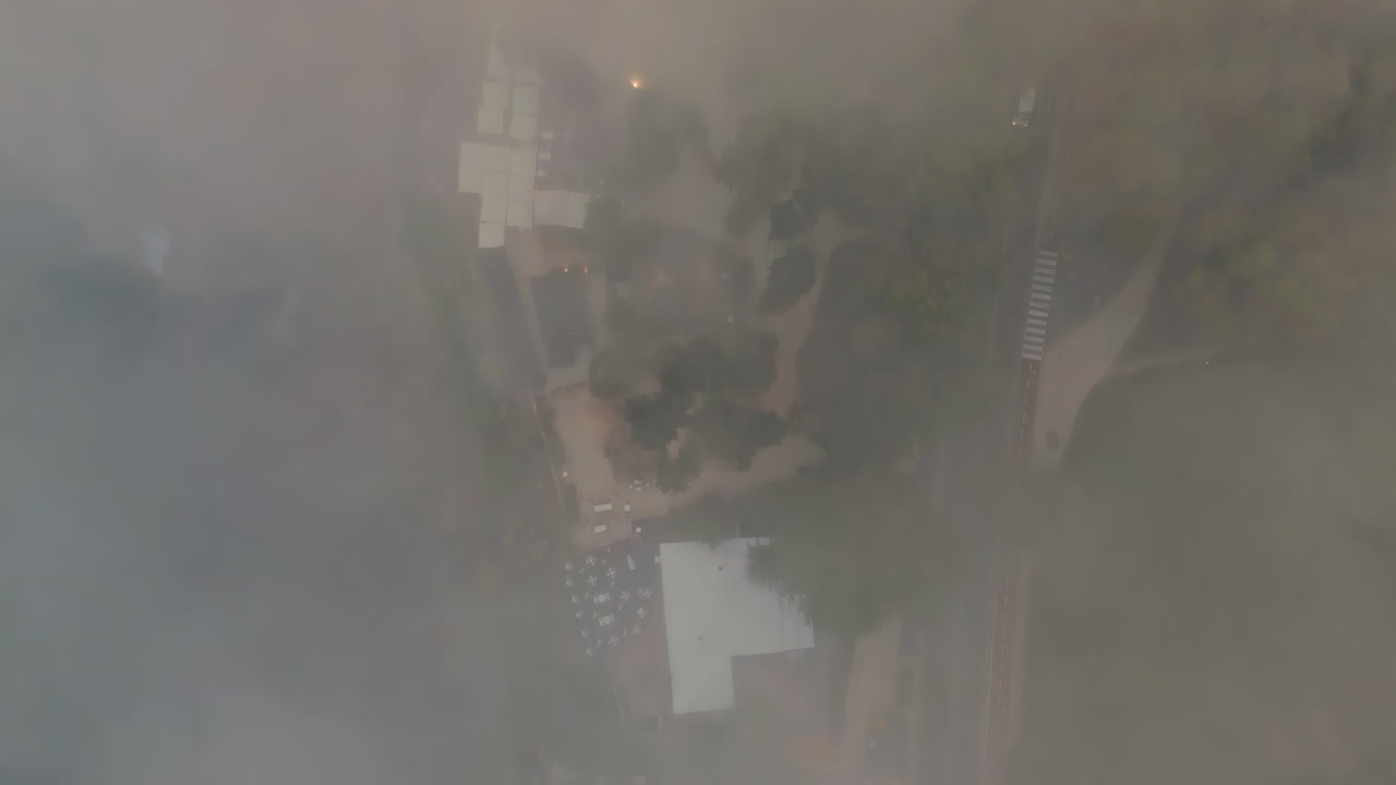 Top view foggy town with tiled roof buildings at evening dusk. Mysterious town