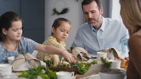 caucasian family of five spending time over table on easter time.