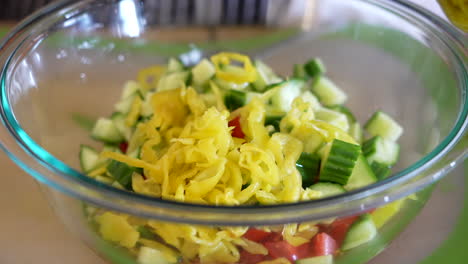 Agregar-Pepperoncini-En-Escabeche-A-Un-Tazón-De-Ingredientes-De-Ensalada-Picados---Serie-De-Ensalada-Antipasto