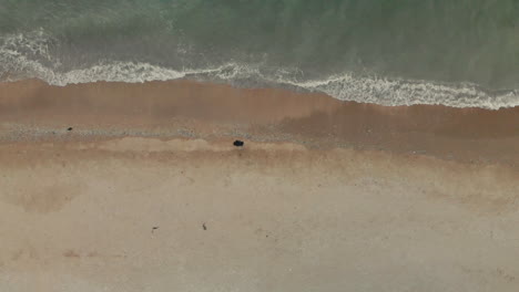 Drohnenaufnahme-Eines-Mannes,-Der-Vor-Dem-Meer-Steht