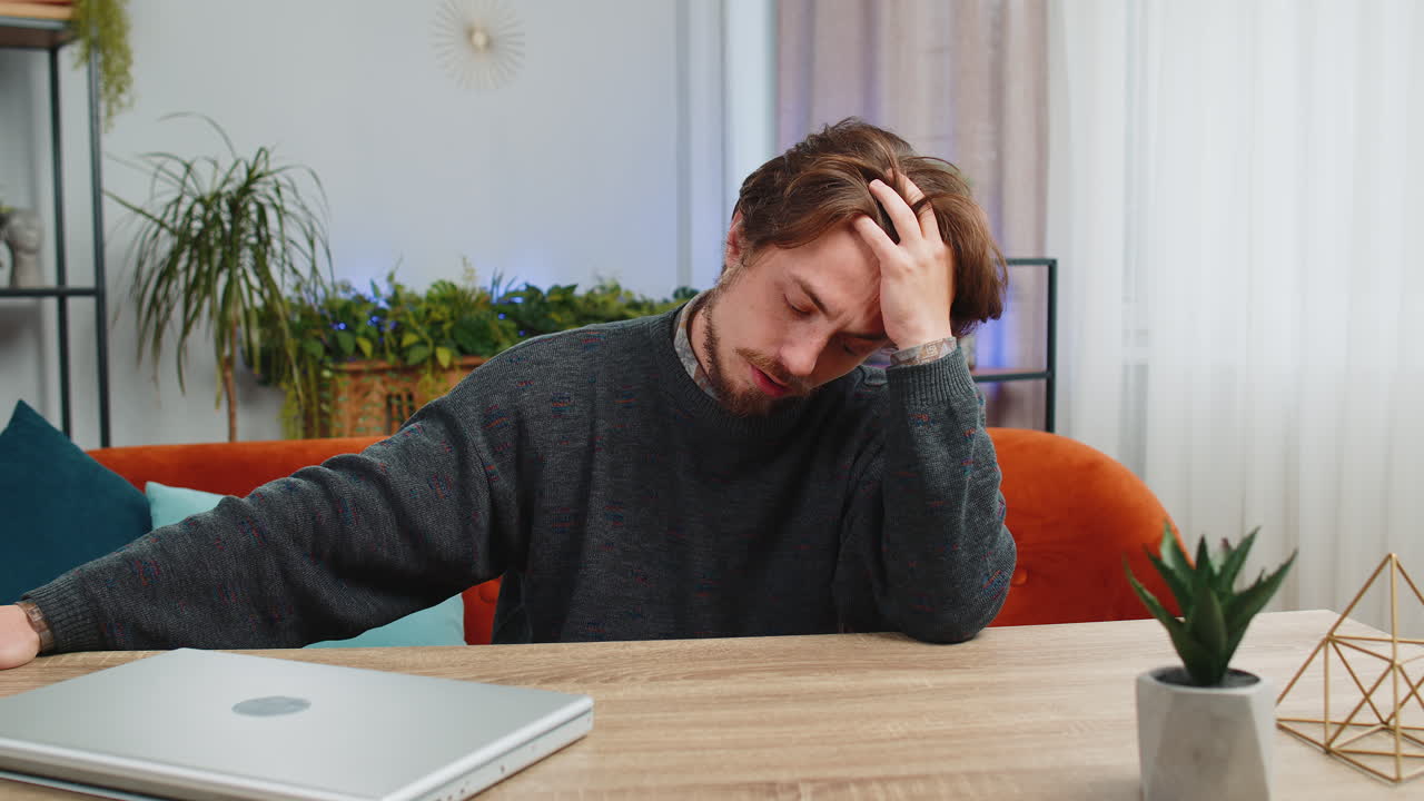 Caucasian man at home suffers from unfair situation problem break up depressed feeling bad burnout