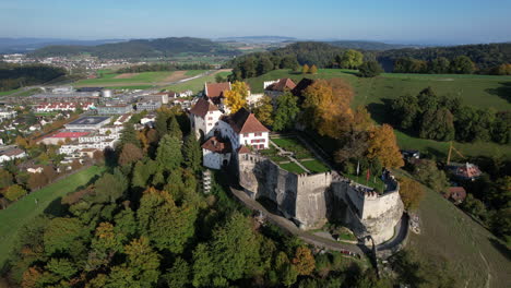 maravillosa toma aérea en órbita en un día soleado del castillo de lenzburg y donde se puede ver la bandera suiza