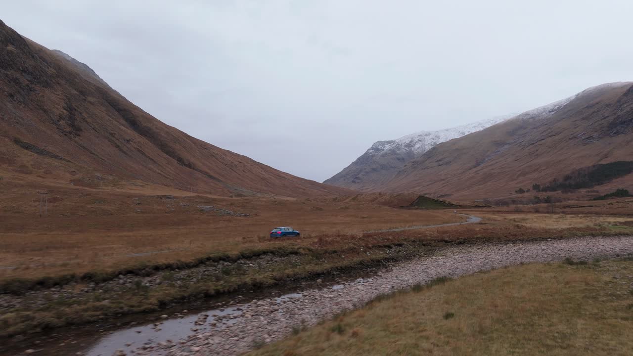 Cinematic tracking shot of a car driving through Glen Etive moors in Scotland