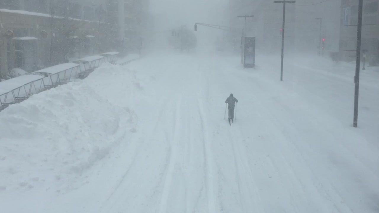 A cross country skier on a normally busy street in Boston, Massachusetts during a winter blizzard.