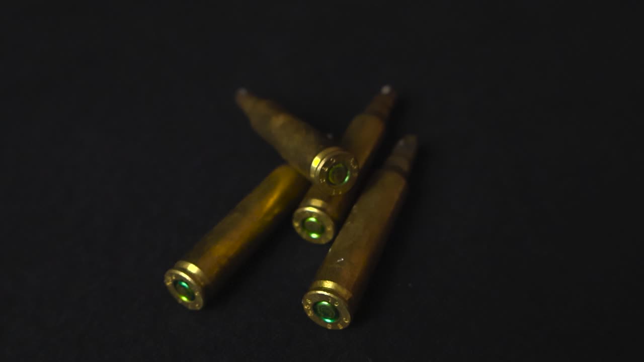 Close up view of bronze and golden colored blank cartridges or high caliber ammo ammunition bullets placed in front of a black studio background with shallow depth of field, Good studio lighting