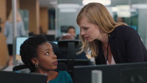 business woman meeting with colleague using computer team leader pointing at screen helping coworker discussing strategy in corporate workplace