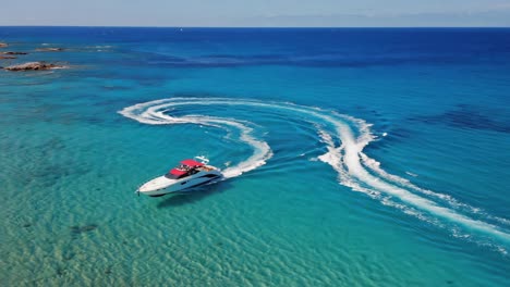 luxury yacht creating wake patterns in clear turquoise ocean waters