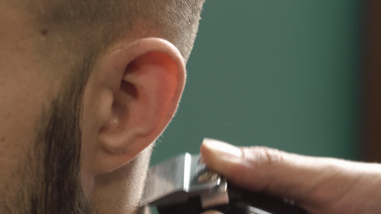 Close-up of a man getting a haircut with a hair clipper