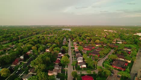 aerial shot of a green suburban neighborhood with houses and trees, captured during sunset, peaceful residential area