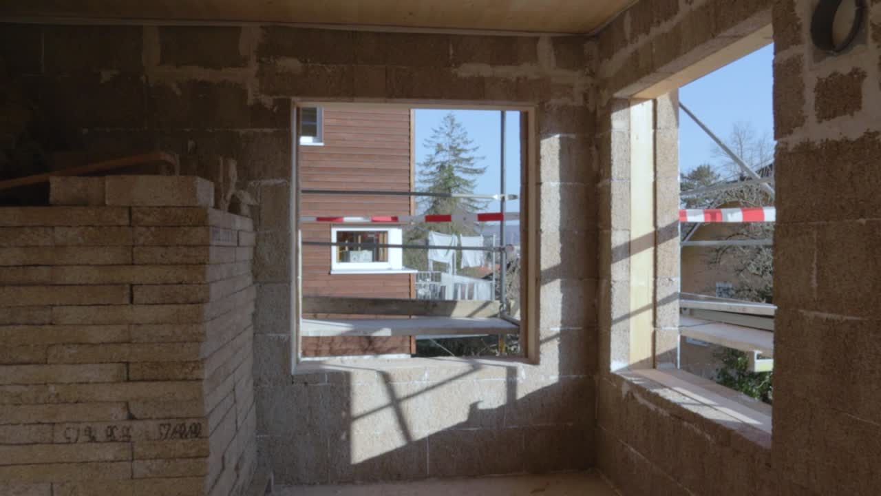 se acerca lentamente a una ventana dentro de un sitio de construcción de hormigón de cáñamo