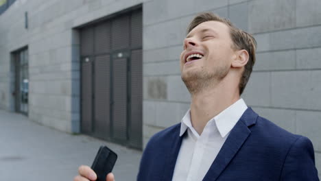 businessman reading good news on smartphone. professional celebrating victory