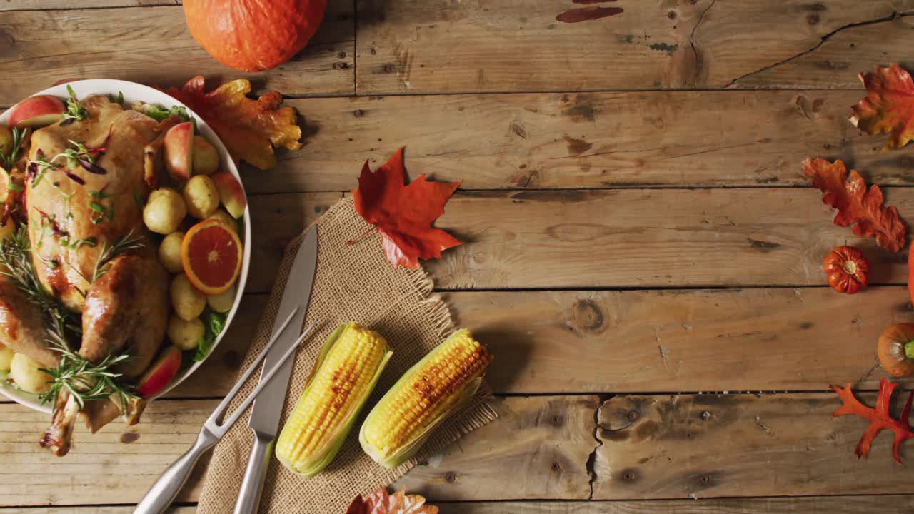 video de una bandeja con pavo asado, patatas y maíz en superficie de madera