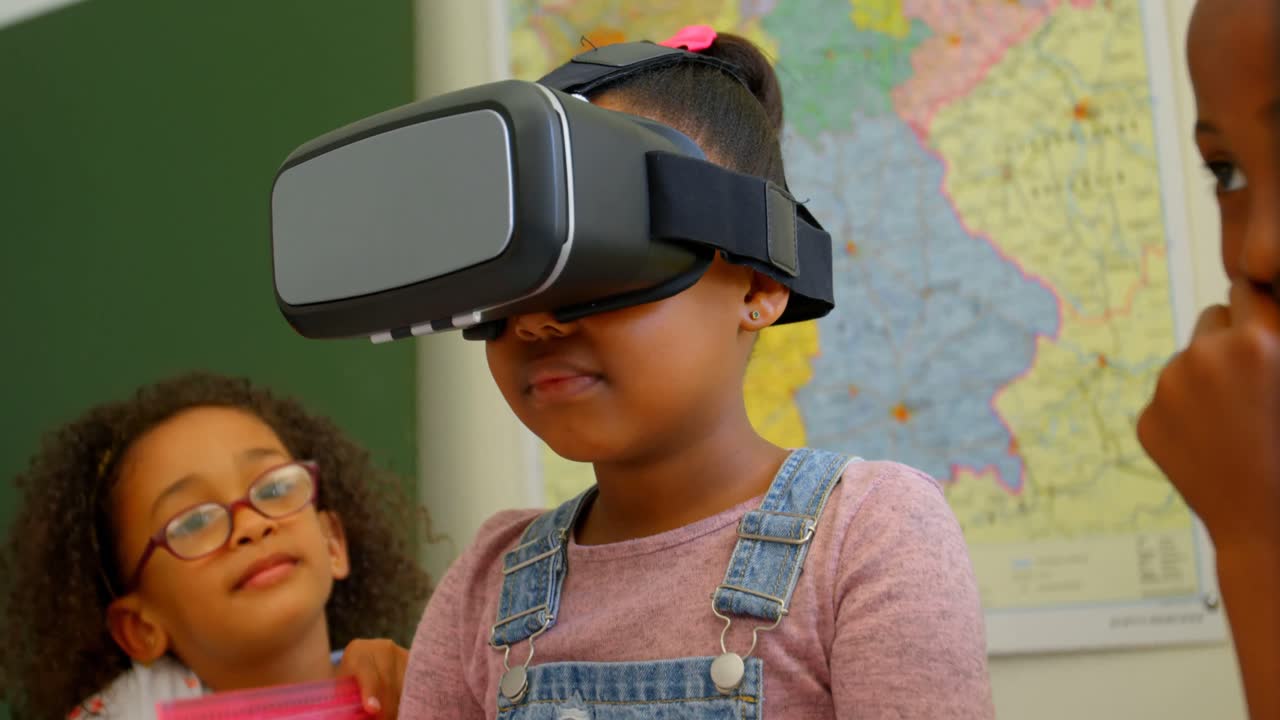 African American schoolgirl using virtual reality headset in classroom at school 4k