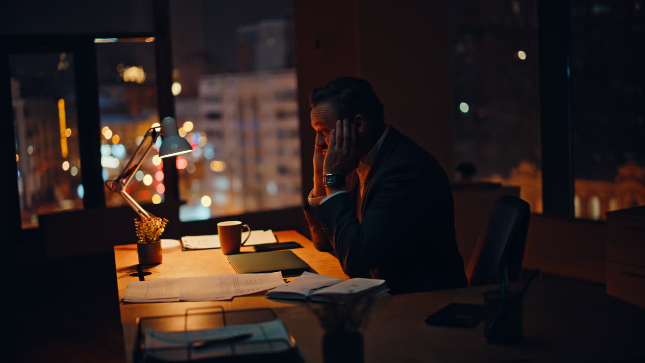 Late manager working pc at company workspace. Tired businessman closing laptop