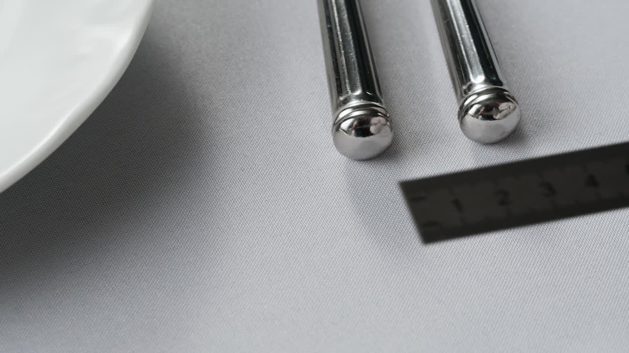 Elegant table setting with white tableware plates, cutlery, and glassware for a classy dining, fancy expensive restaurant dinner