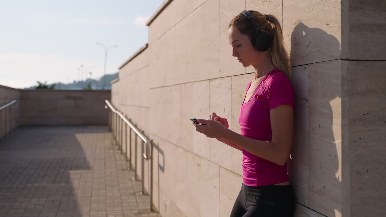 mujer escuchando música y usando el teléfono al aire libre