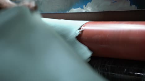 person operating a industrial leather buffing machine in production line