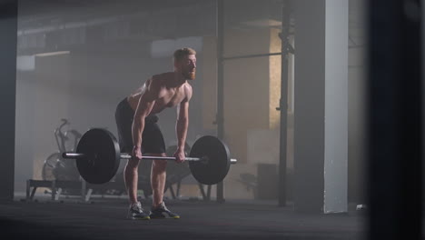 slow motion: male powerlifter preparing for training in gym. screaming man lifting weights