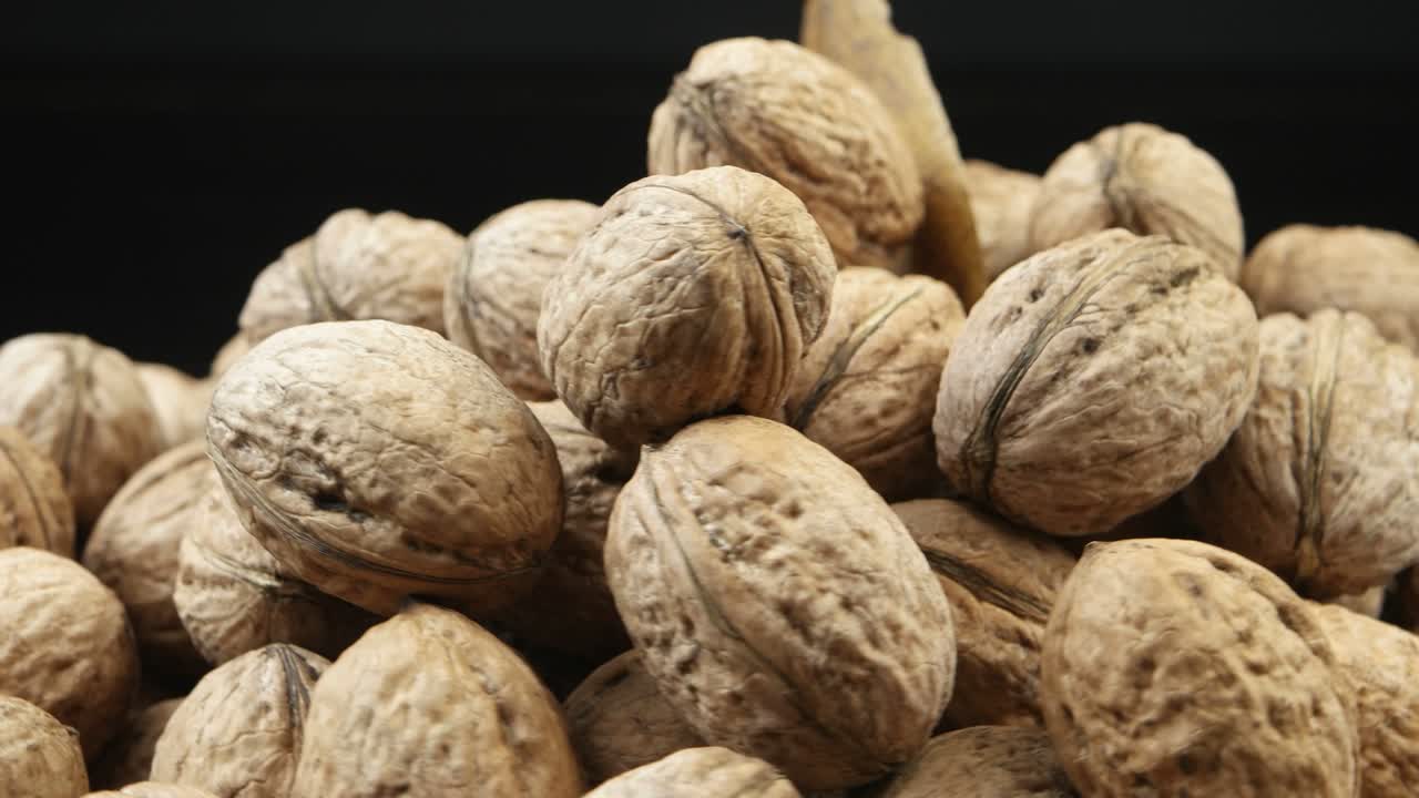 A pile of walnuts lies on a board