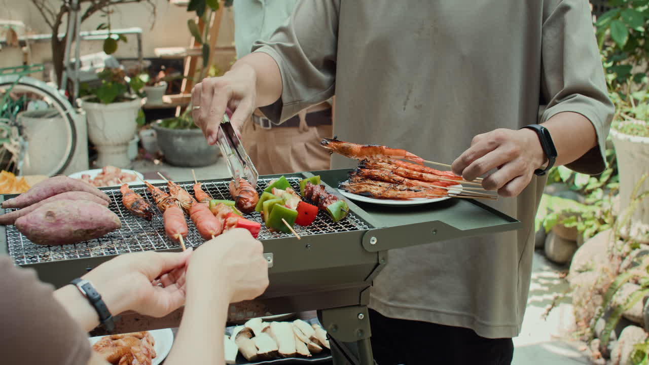 Man Cooking on Barbecue during Outdoor Party with Friends