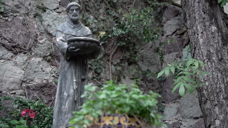 sculpture of a man holding a basket in the park