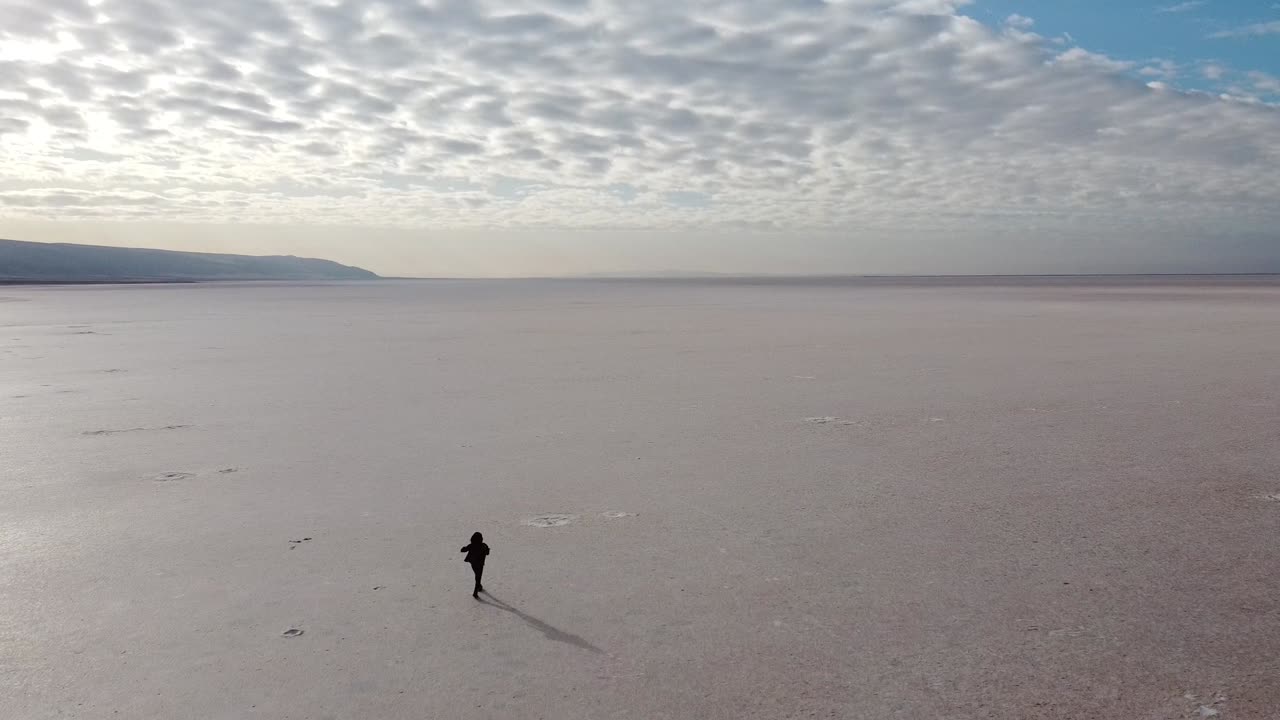 터키에서 가장 큰 마른 호수이자 세계에서 가장 큰 소금 호수 중 하나인 분홍 소금 호수를 걷고 있는 아름다운 소녀