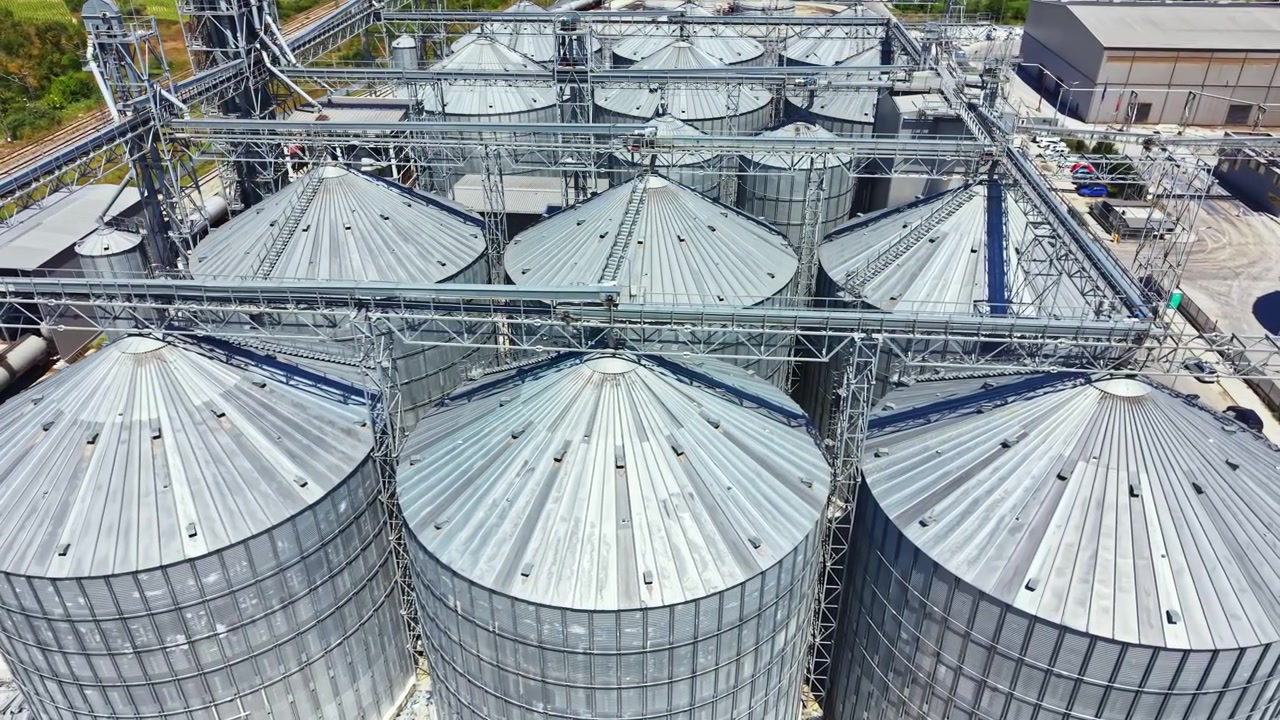 Silos and storage facilities at an agricultural site during sunny weather in a rural area