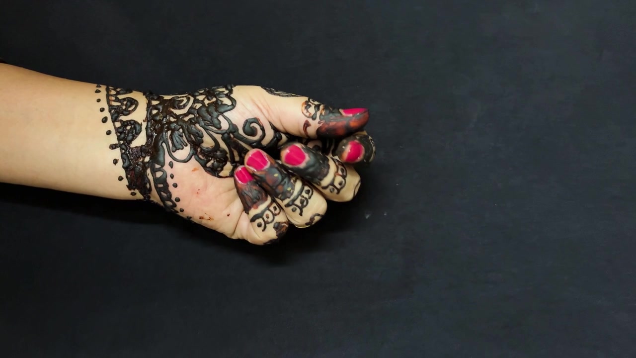 Motivo mehendi nuziale con eleganti decorazioni all'henné nero sulle dita e sul palmo.