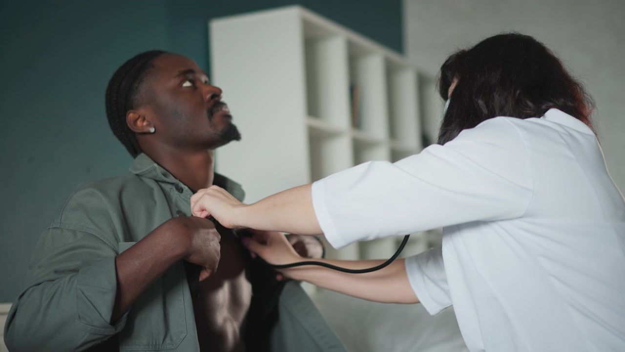 Male patient chest exam in bedroom by nurse using stethoscope, tense atmosphere with quick assessment, shirt pulled aside, nurse listening to lungs, checking vitals, paramedic style response