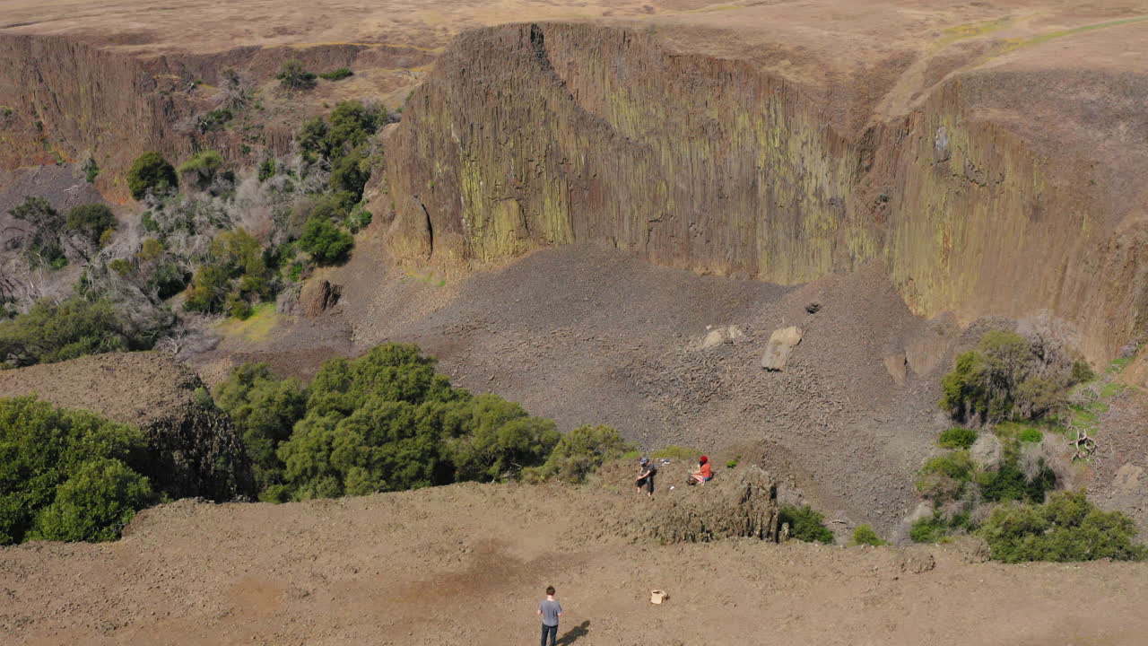 visitantes de pie al borde del acantilado en table mountain, oroville, california