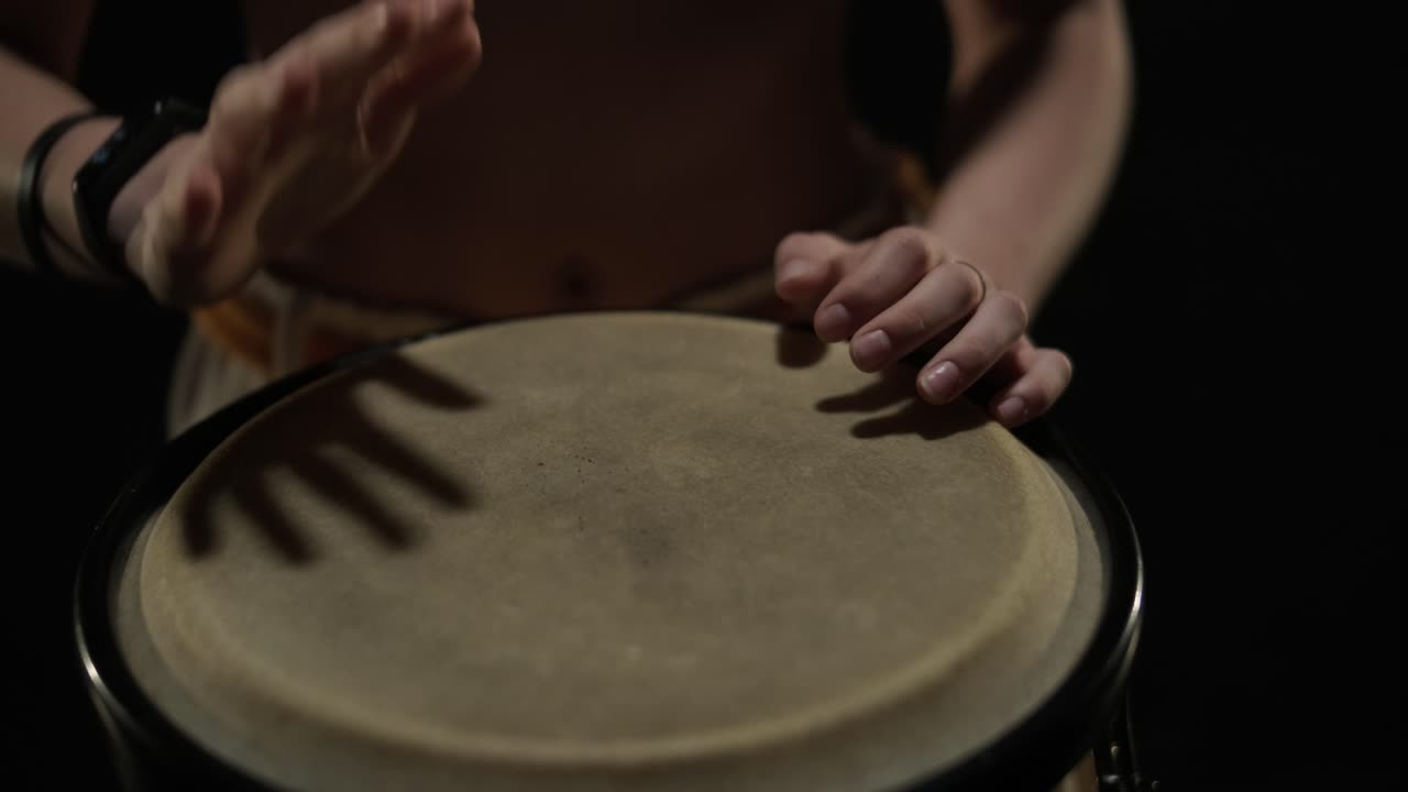 un grupo de bailarines profesionales están practicando capoeira en la oscuridad contra un foco de luz en un fondo negro de estudio. arte marcial afro-brasileño que combina elementos de la danza.