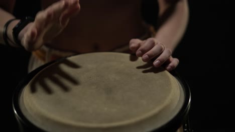 group of a professional dancers are practicing capoeira in darkness against a spotlight on a black background of studio. afro-brazilian martial art that combine elements of dance.