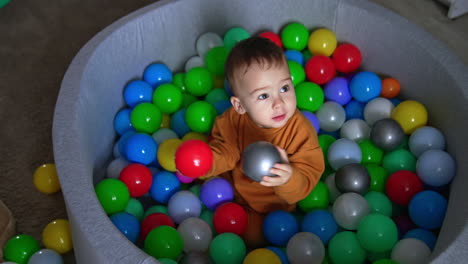 baby playing in a colorful ball pit