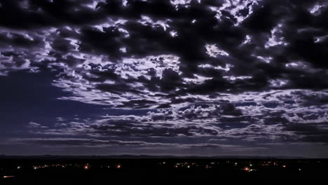 Dramatischer-Nächtlicher-Zeitraffer-Von-Wolken,-Die-Nachts-über-Den-Kopf-Ziehen-Und-Das-Mondlicht-über-Der-Marokkanischen-Stadt-Reflektieren