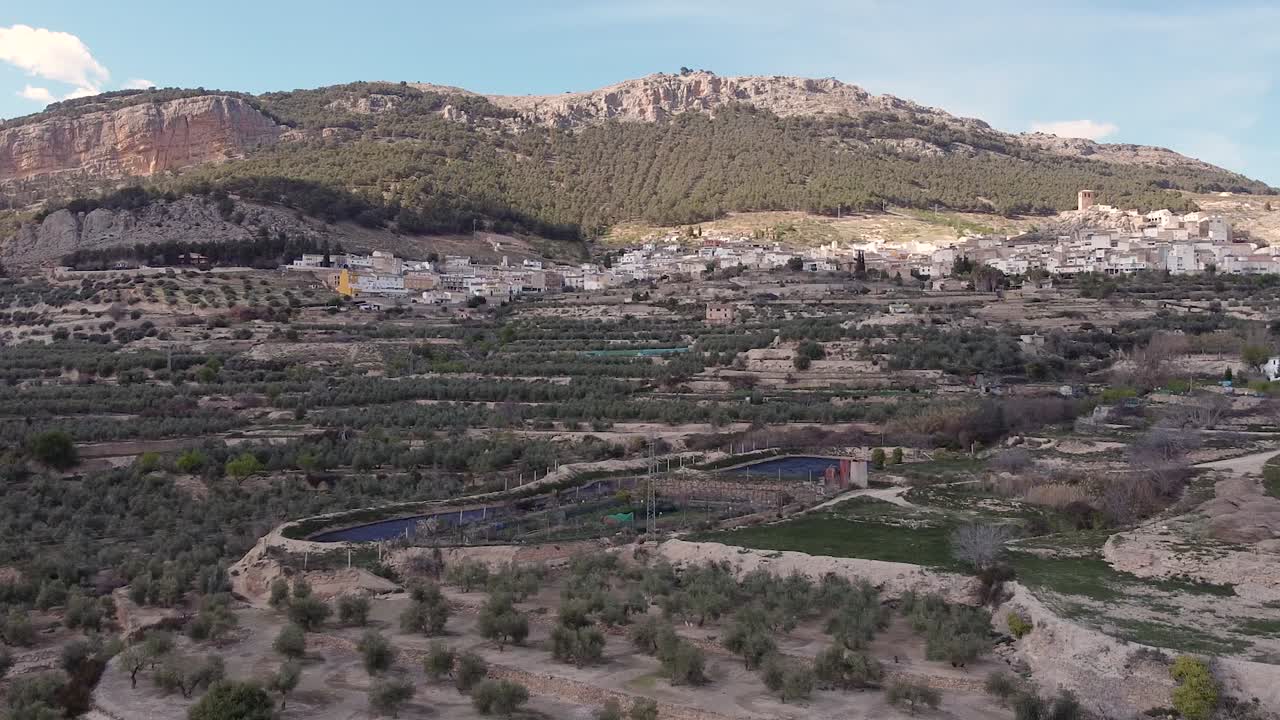 imagen aérea de un pueblo andaluz rodeado de montañas con huertos