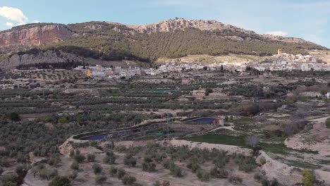 Imagen-Aérea-De-Un-Pueblo-Andaluz-Rodeado-De-Montañas-Con-Huertas.