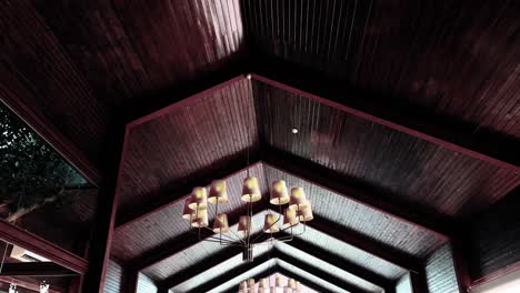 interior view of dark wood ceiling with hanging chandeliers in elegant hall