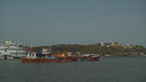 Eine-Statische-Aufnahme-Eines-Krankahns-Und-Eines-Pontons,-Die-An-Einem-Schönen-Sonnigen-Tag-Im-Mandovi-fluss-Verankert-Sind,-Panjim,-Indien