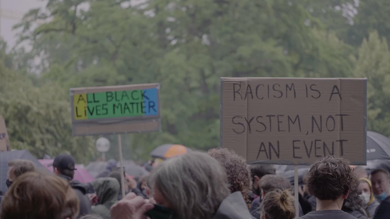 Crowd of protester holding signs against racism and for justice at a black lives matter protest in Stuttgart, Germany.