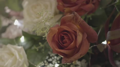 Nahaufnahme-Eines-Blumenstraußes-Mit-Rosa-Und-Weißen-Rosen,-Grünen-Blättern,-Zweigen,-Tragbarer,-Nostalgischer-Und-Verblasster-Farbe