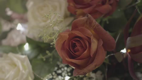 close crop shot of a flower bouquet with pink and white roses green leaves, sprigs, handheld, nostalgic and color faded look