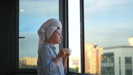 woman enjoying coffee by the window